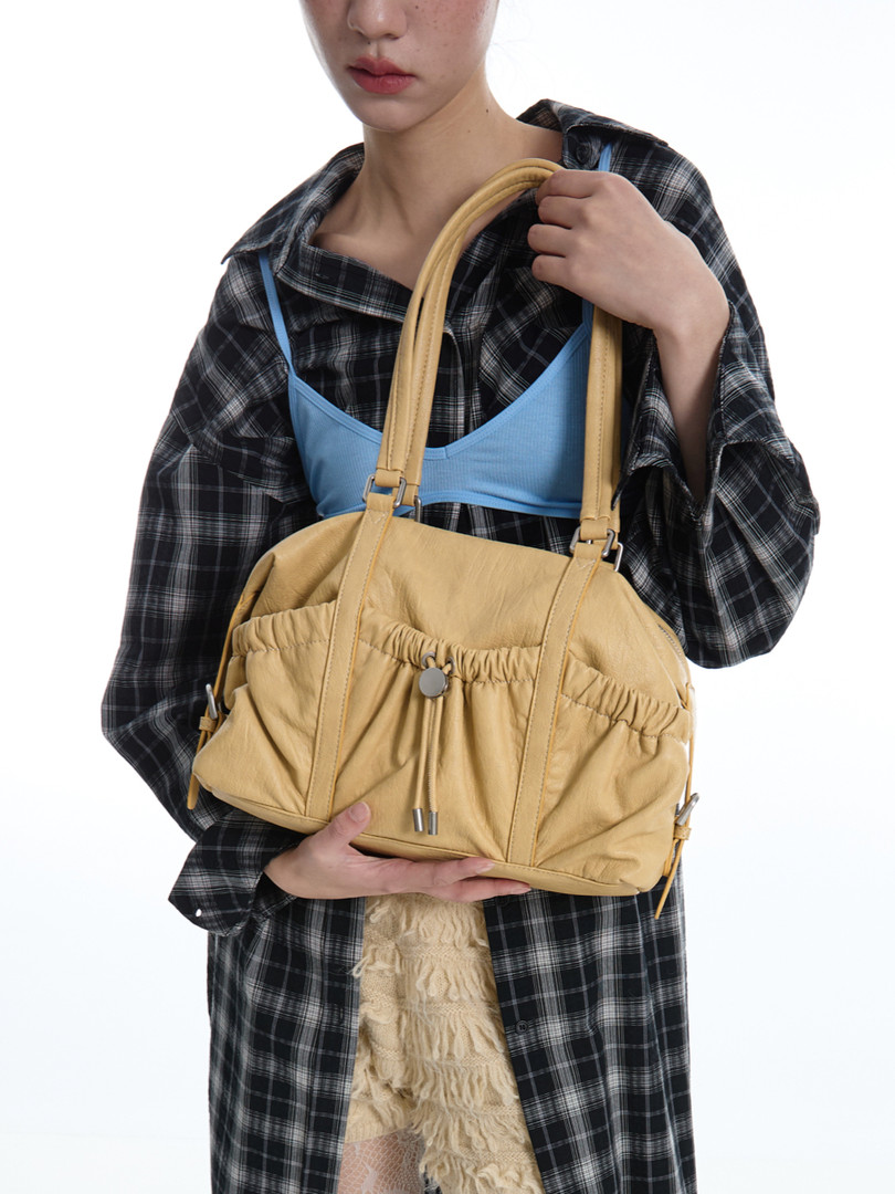 Yellow shoulder handbag held by a model
