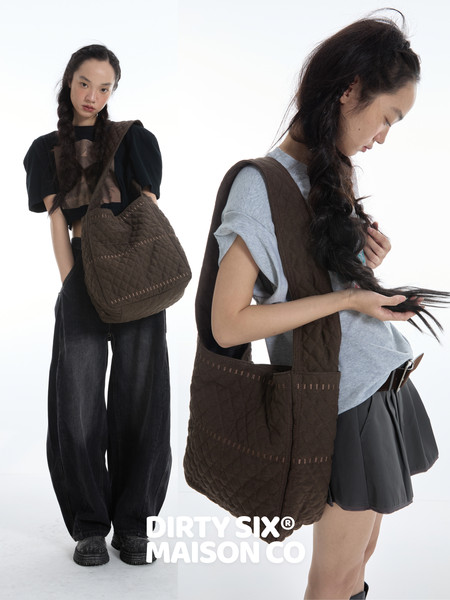 Brown quilted tote bag worn by a model in a studio fashion shot