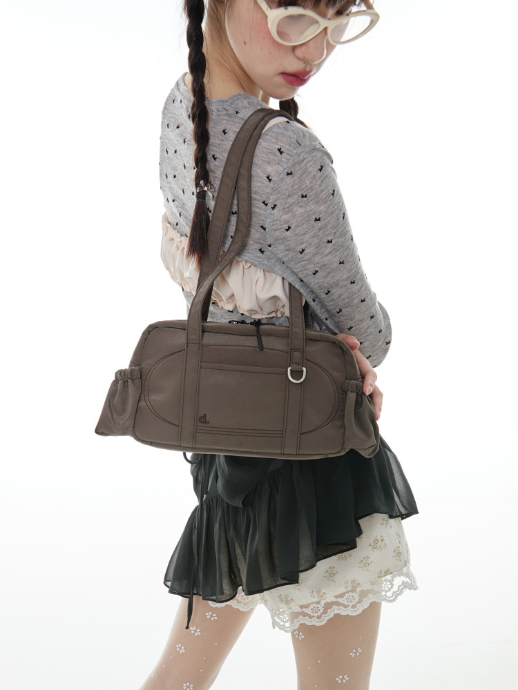 Brown shoulder bag worn by a model