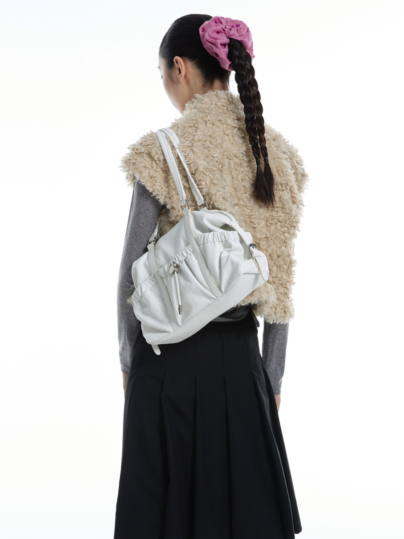 White backpack bag worn on the back of a model