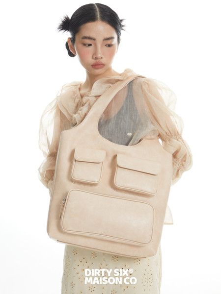 Beige oversized tote bag worn by a model