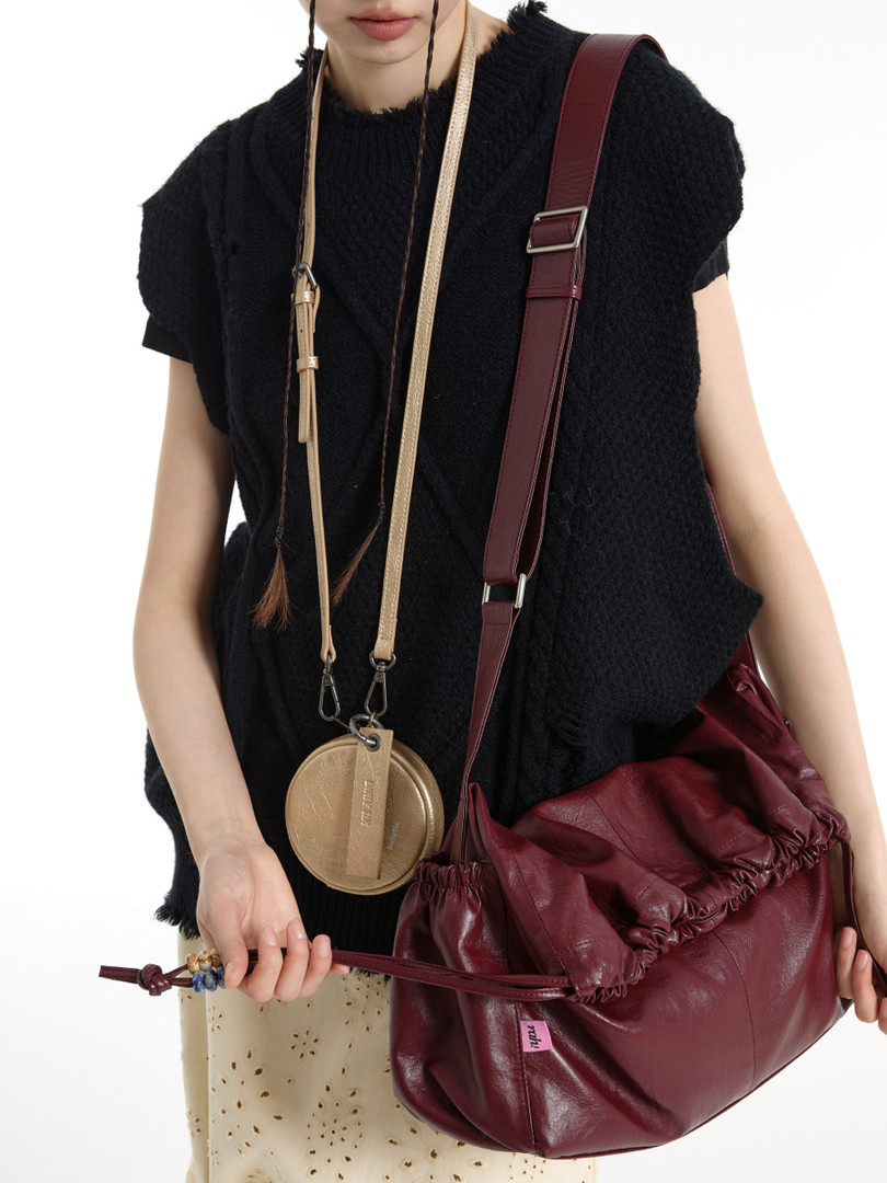 Burgundy leather shoulder bag worn by a model