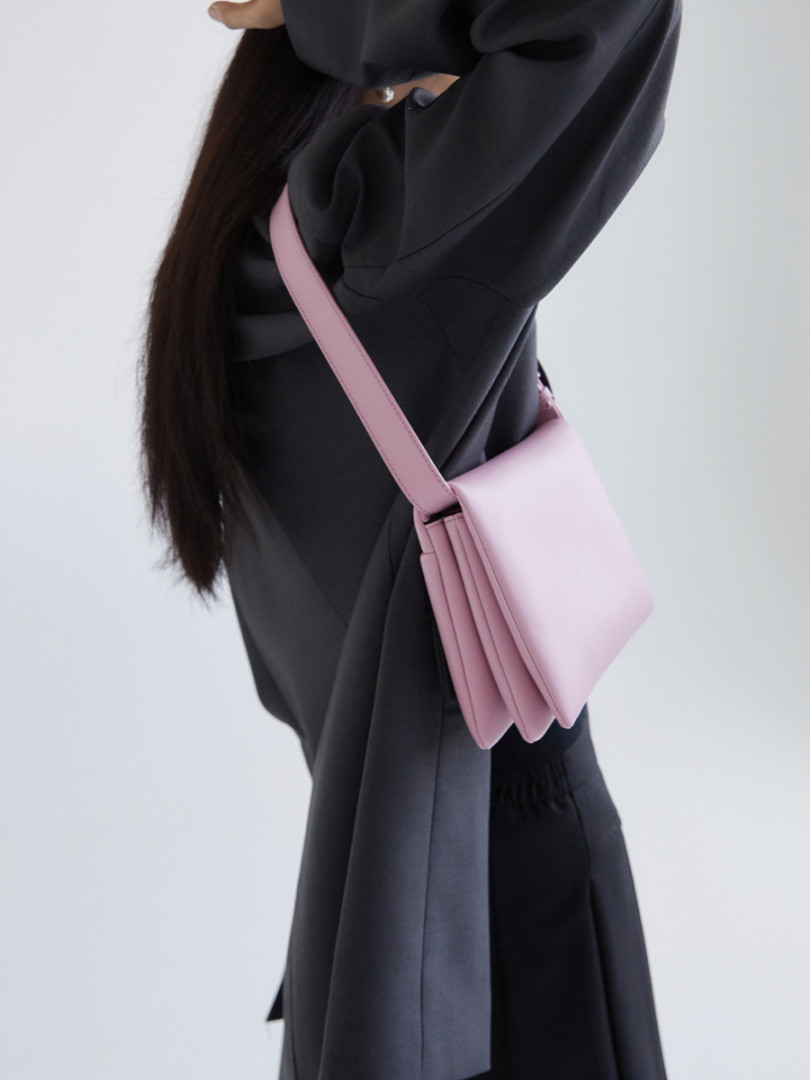 Pink shoulder bag worn crossbody on a model
