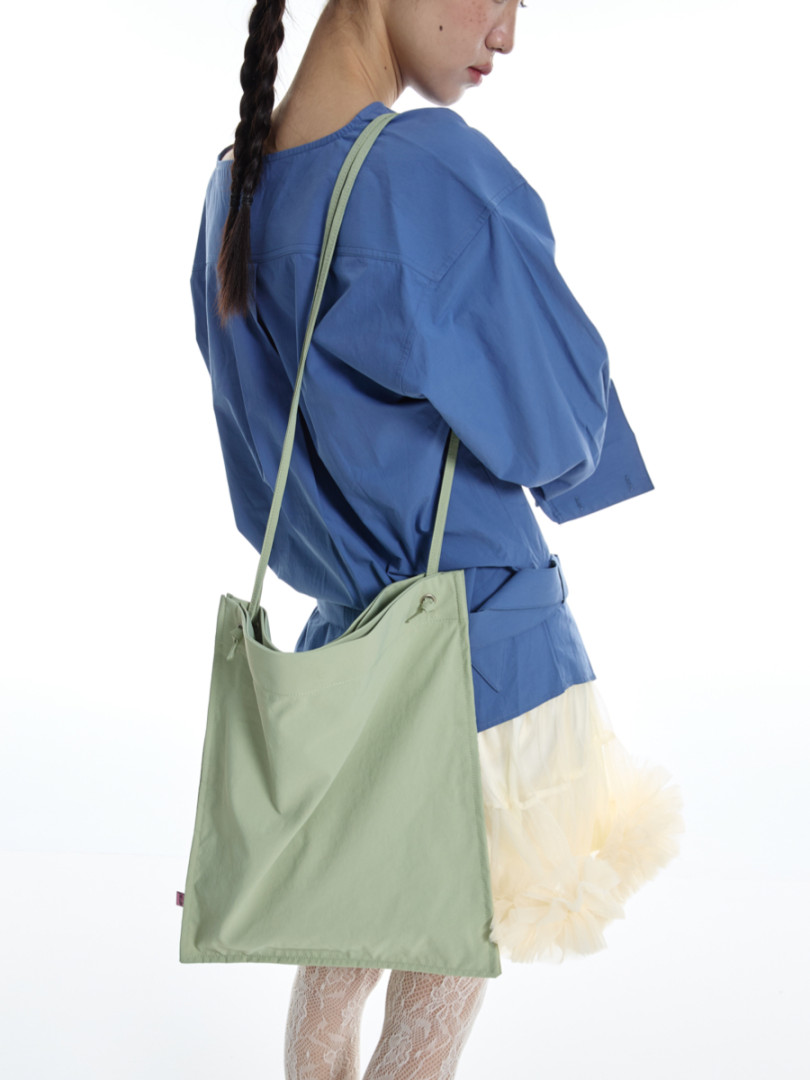 Light green shoulder tote bag worn by a model