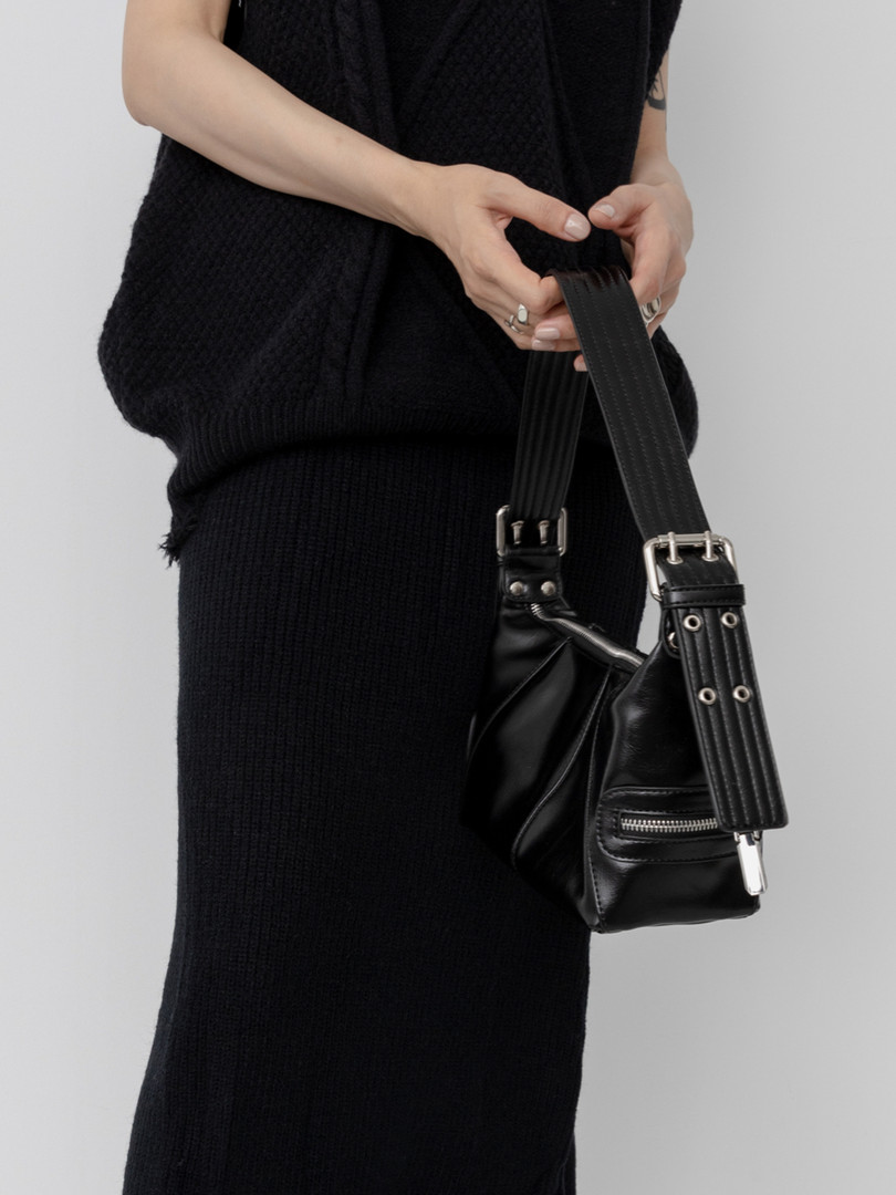 Black leather shoulder bag held by a model