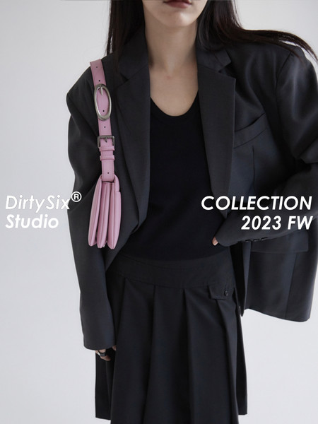 Woman wearing a black blazer and skirt with a pink shoulder bag