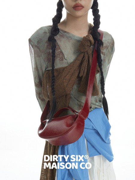 Model wearing a layered fashion outfit with a red crossbody bag