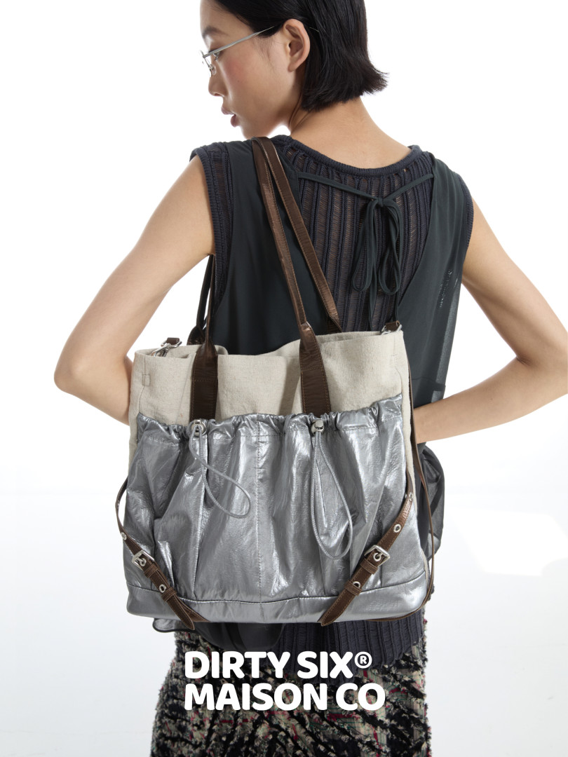 Model wearing a silver and beige tote bag