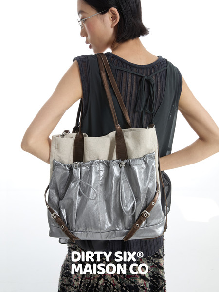 Model wearing a silver and beige tote bag