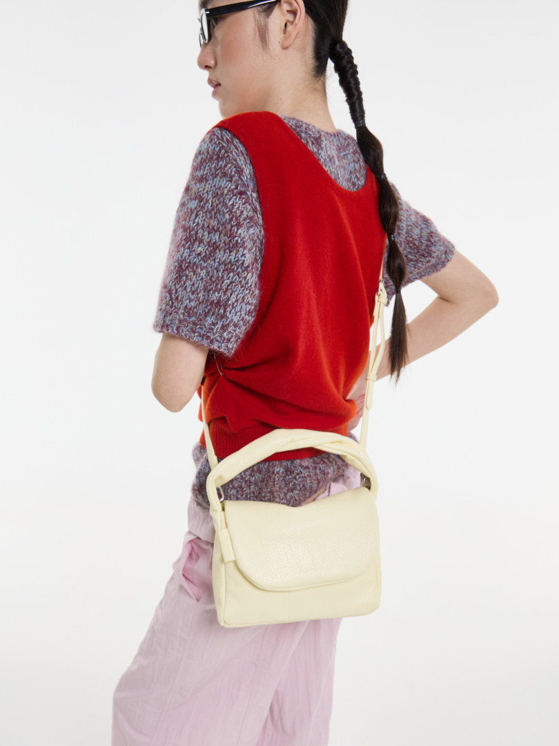Cream crossbody shoulder bag worn by a model