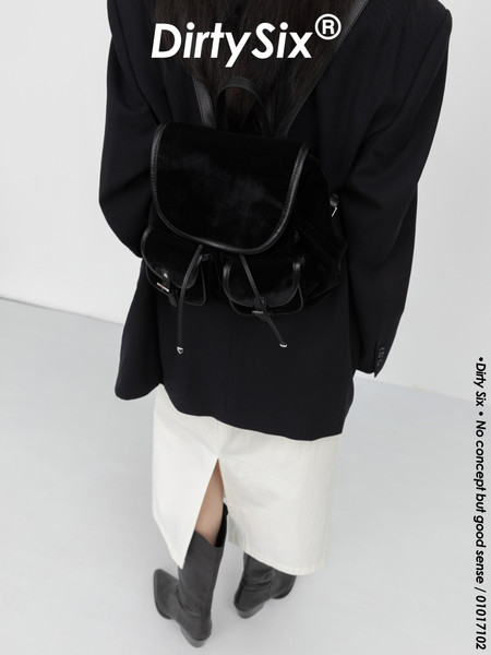 Black backpack worn with a black outfit and white skirt