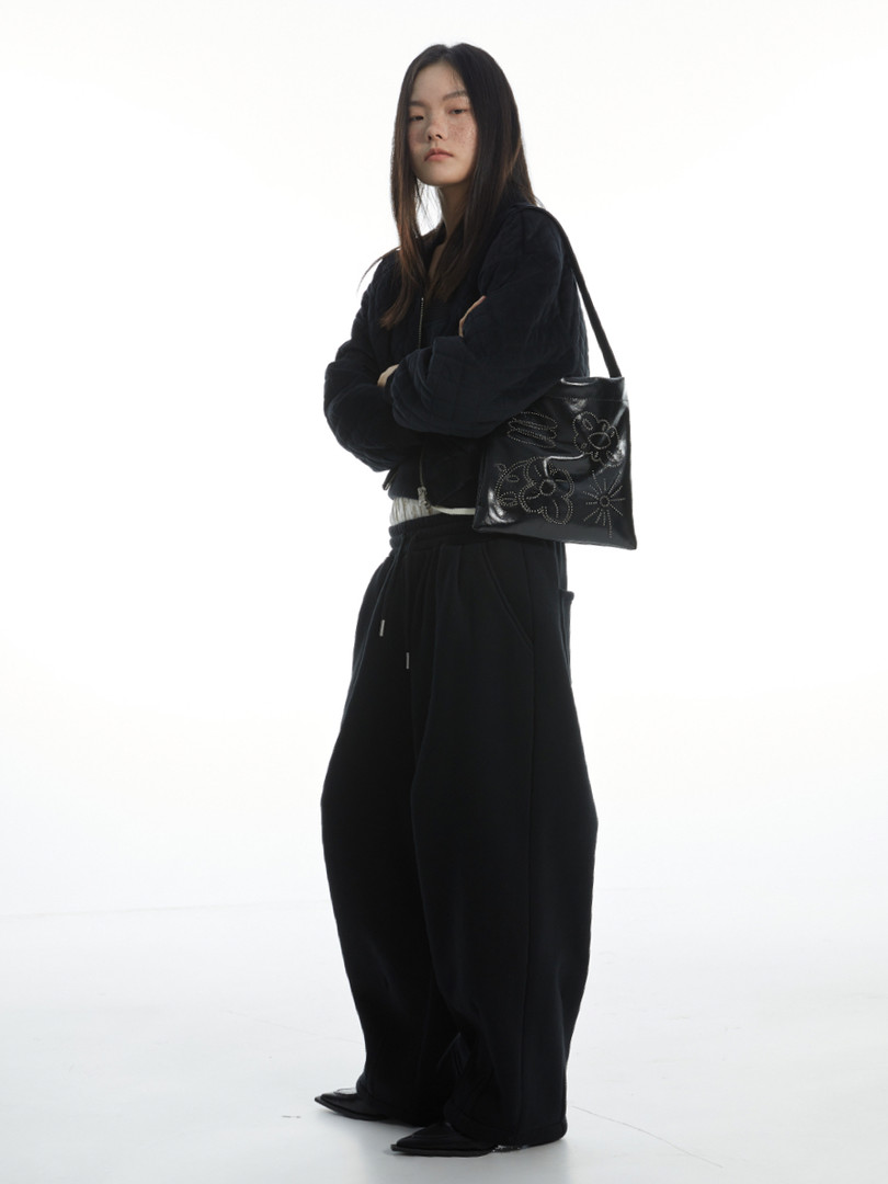 Model wearing an all-black outfit with a black shoulder bag