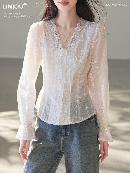 White lace long-sleeve blouse worn by a model with jeans