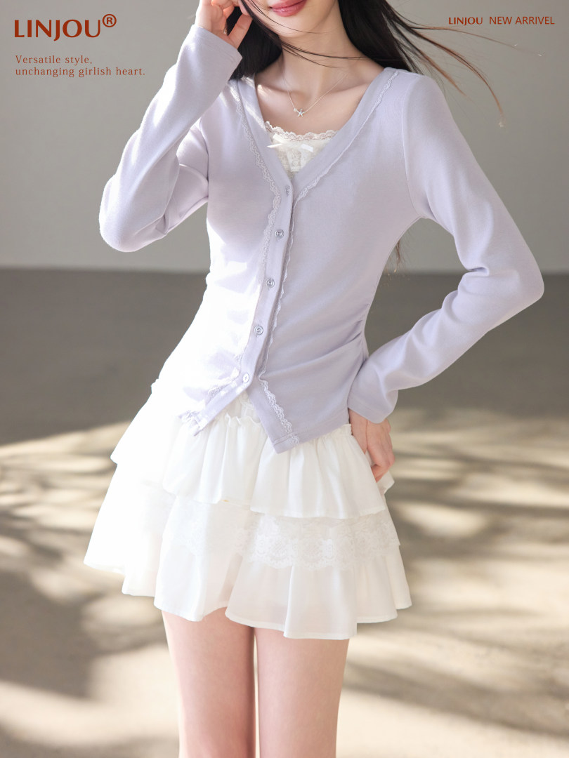 Model wearing a light lavender button-front cardigan with a white layered skirt