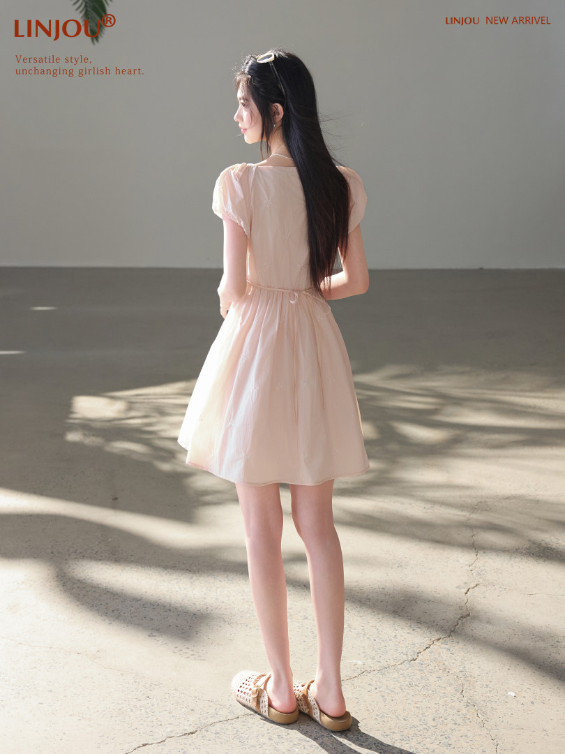 Light pink short-sleeve dress worn by a model from the back