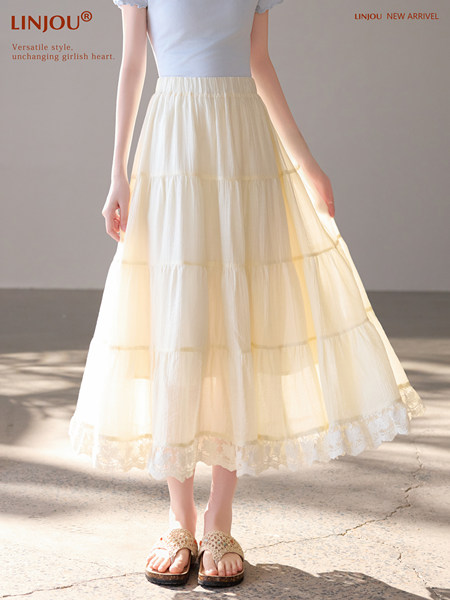 Cream tiered maxi skirt worn by a model with lace-trim hem