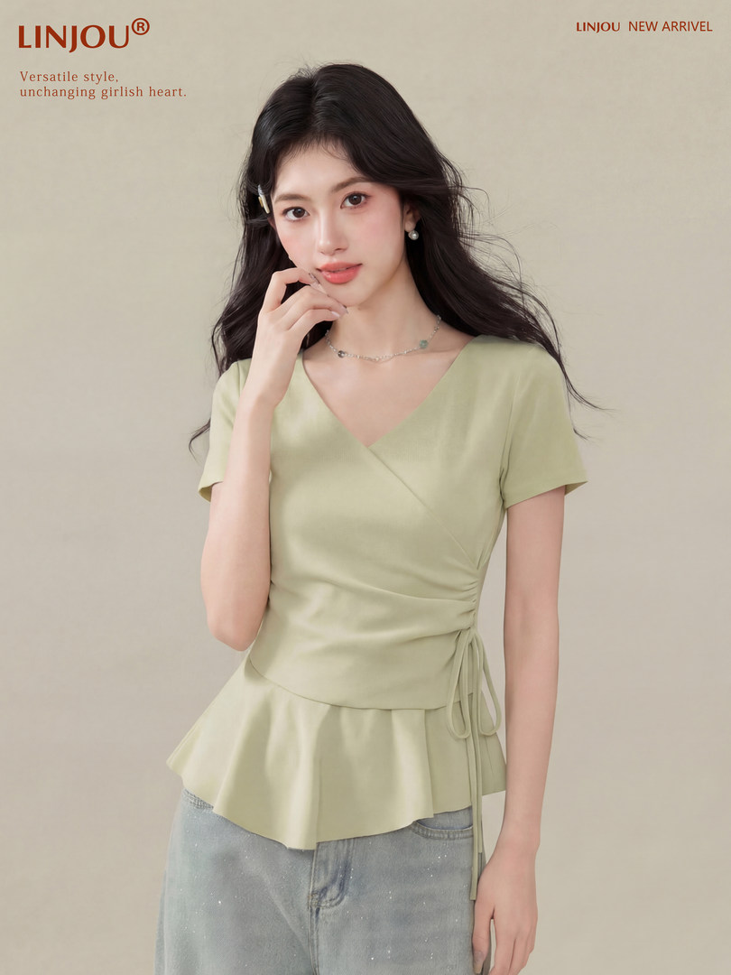 Woman wearing a light green wrap-style short-sleeve top with peplum hem