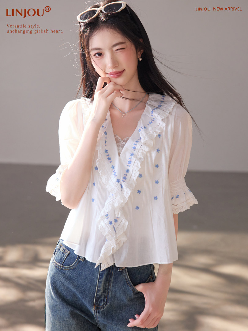 White ruffled blouse worn with jeans on a model