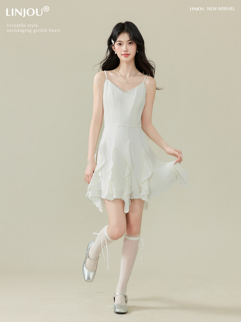 Model wearing a white sleeveless ruffled dress with lace details