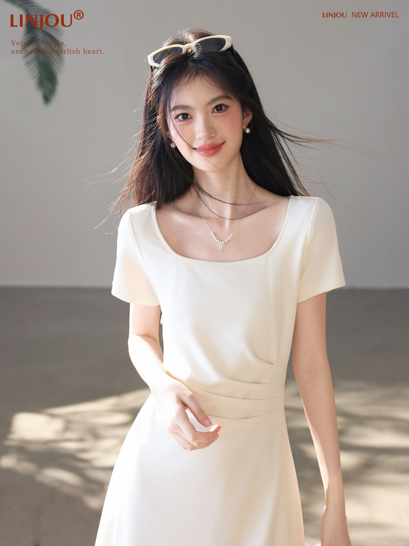 Woman wearing a white short-sleeve dress with a square neckline