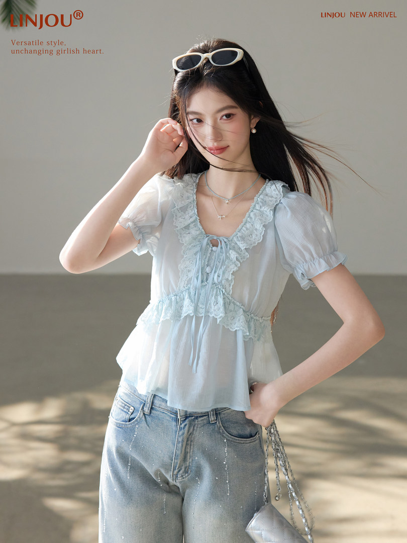 Model wearing a light blue lace-trim puff-sleeve blouse with jeans