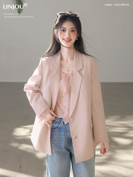 Model wearing a light pink blazer jacket with jeans