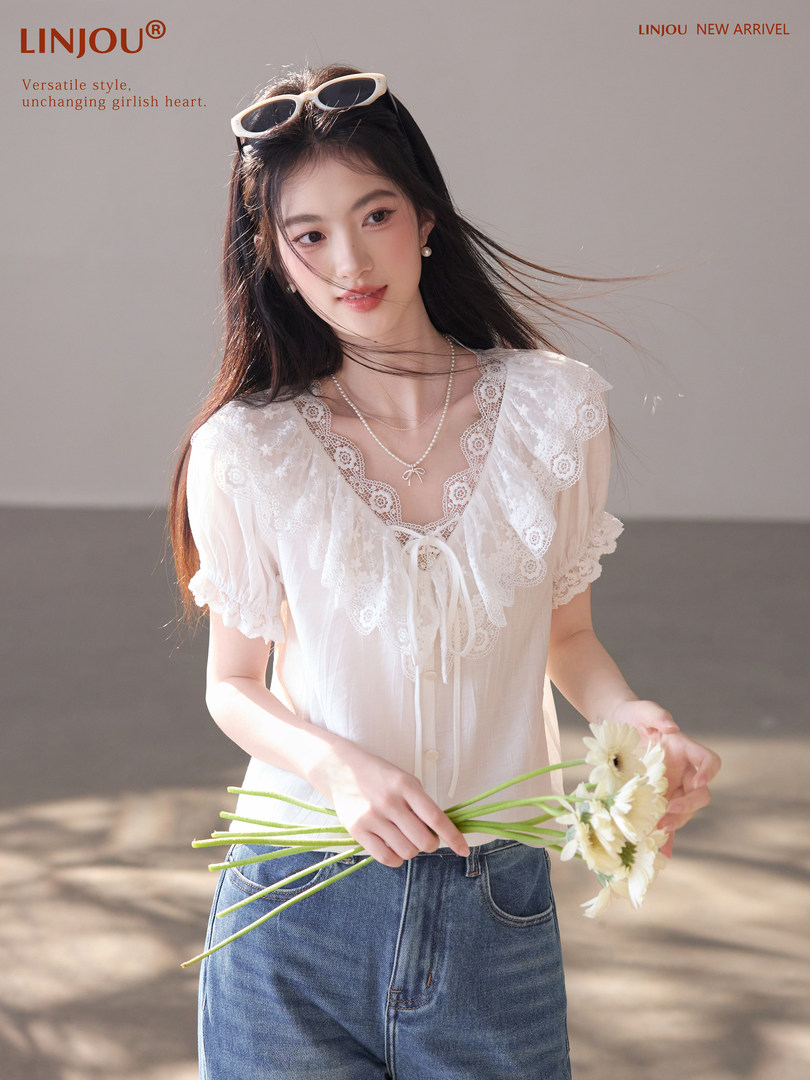 White lace short-sleeve blouse worn by a model with jeans