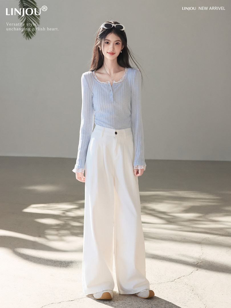 Woman wearing a light blue ribbed lace-trim top with white wide-leg pants