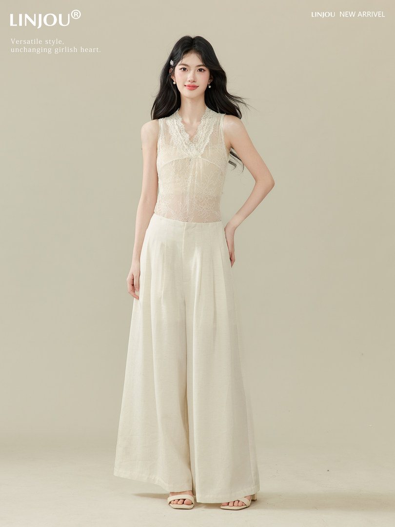 Model wearing a cream lace sleeveless top with wide-leg pants
