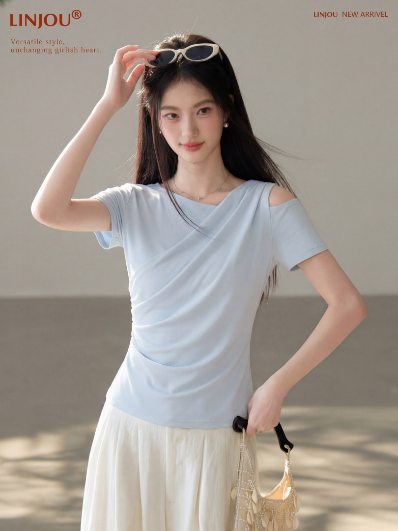 Woman wearing a light blue draped top with a cream skirt