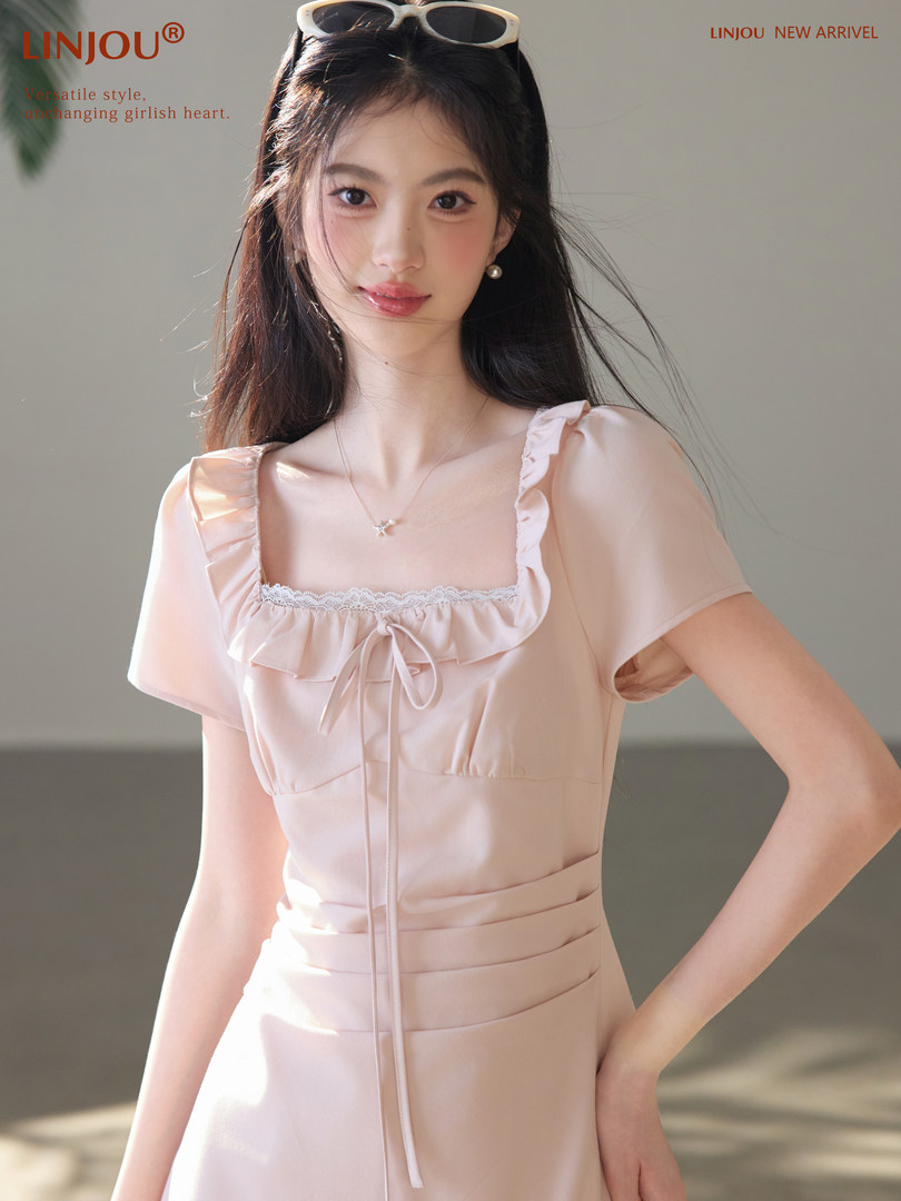 Model wearing a light pink ruffled dress with square neckline