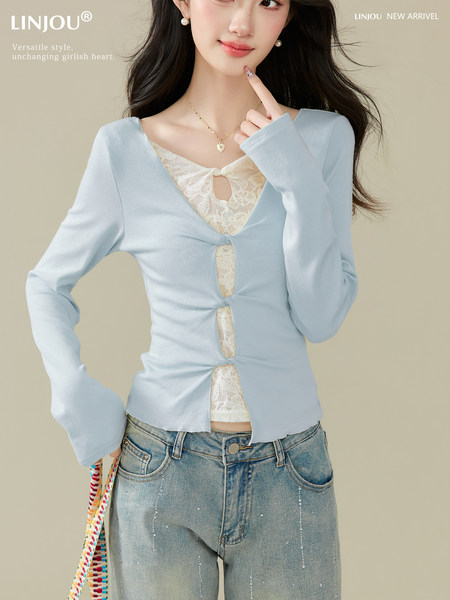 Model wearing a light blue long-sleeve lace-inset top with jeans