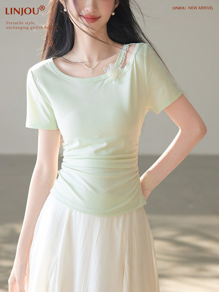 Light mint short-sleeve fitted top worn by a model with a floral shoulder detail
