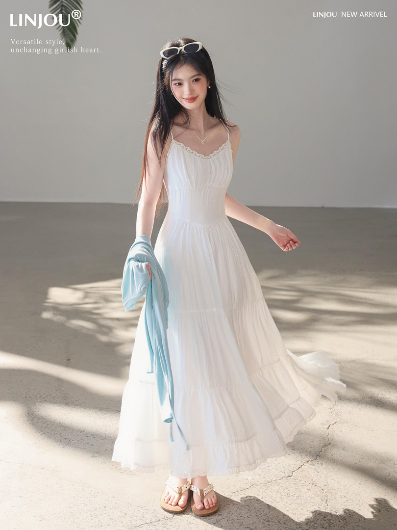 Model wearing a white flowy spaghetti-strap dress