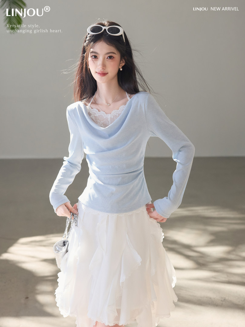 Woman modeling a light blue long-sleeve top with a white lace skirt
