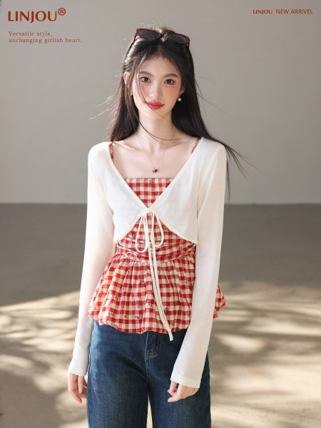 Model wearing a white cropped tie-front cardigan over a red gingham top with jeans