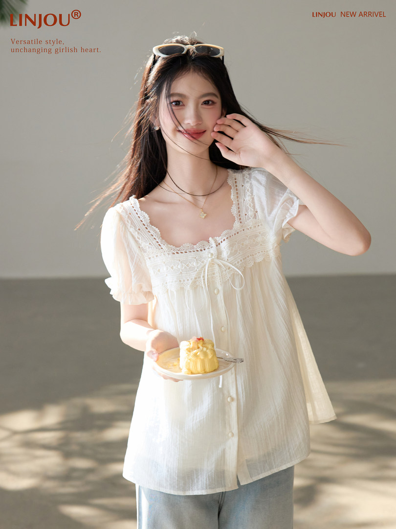 Woman wearing a white lace-trimmed short-sleeve dress or blouse