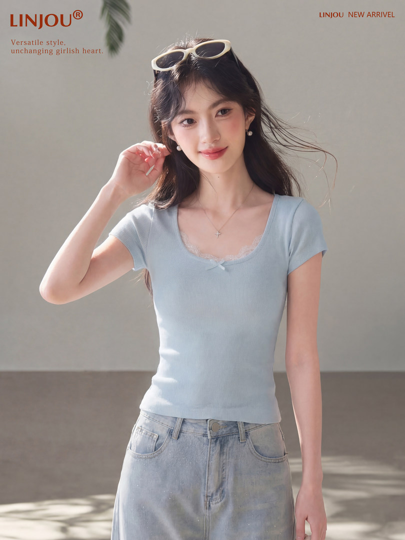 Woman wearing a light blue fitted short-sleeve top with lace neckline and light wash jeans