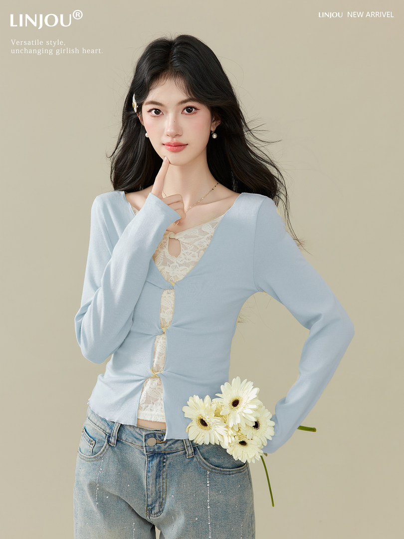 Model wearing a light blue long-sleeve lace-trim top with jeans