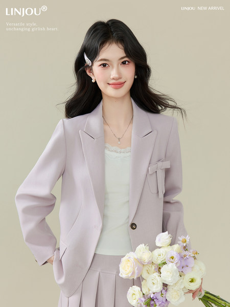 Light lavender blazer suit worn by a female model with a matching skirt and white top