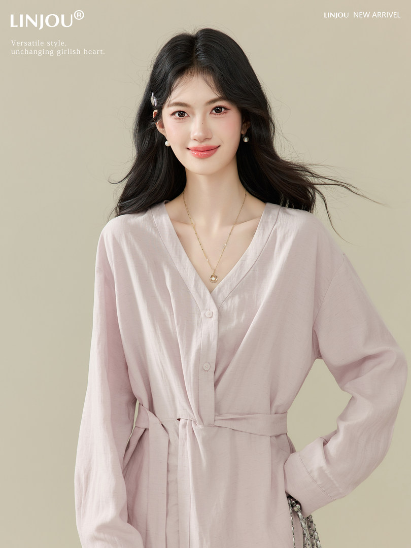 Model wearing a light pink belted long-sleeve dress or robe-style outfit