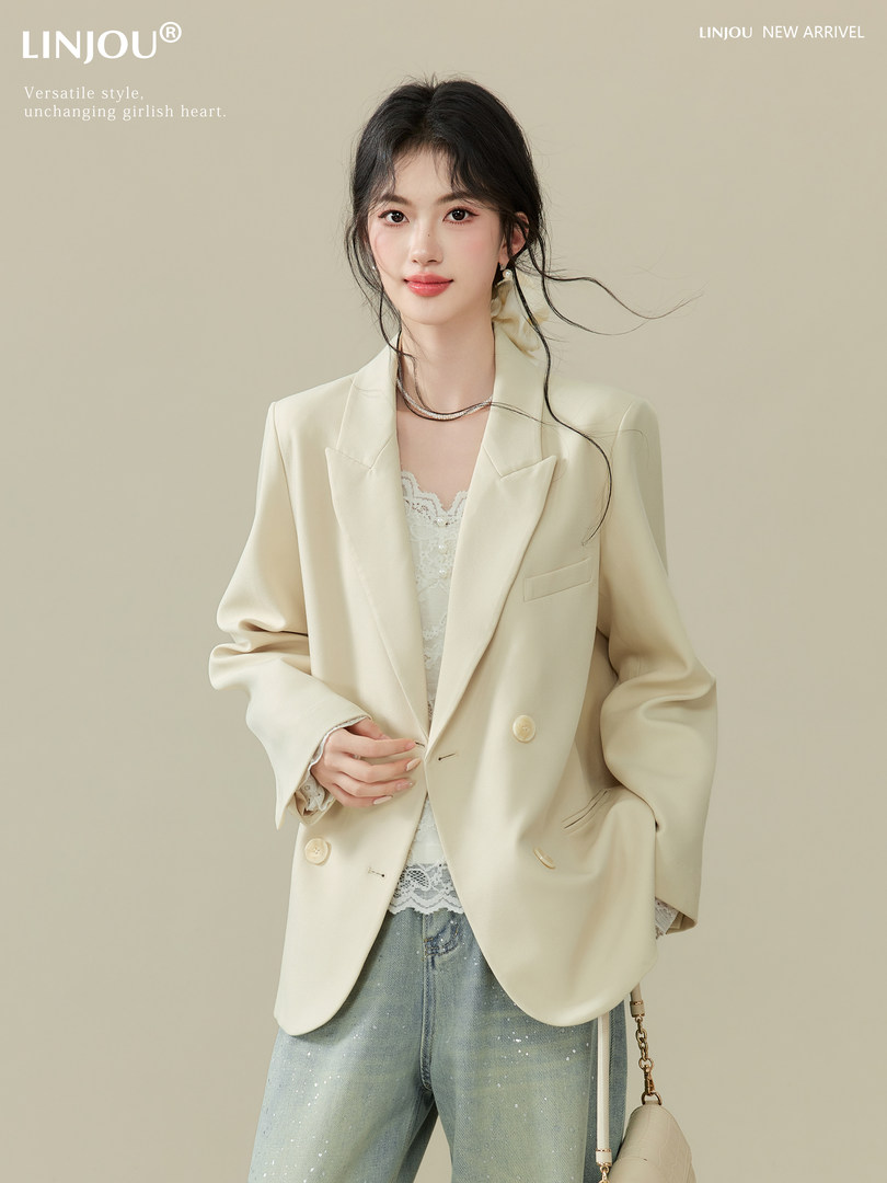 Cream blazer outfit worn by a model with lace top and light denim jeans