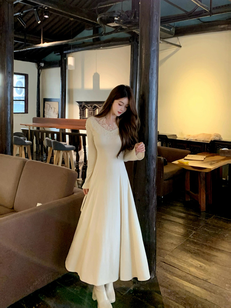 Woman wearing a cream long-sleeve lace-trim dress indoors
