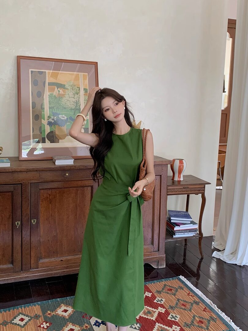 Woman wearing a green sleeveless midi dress