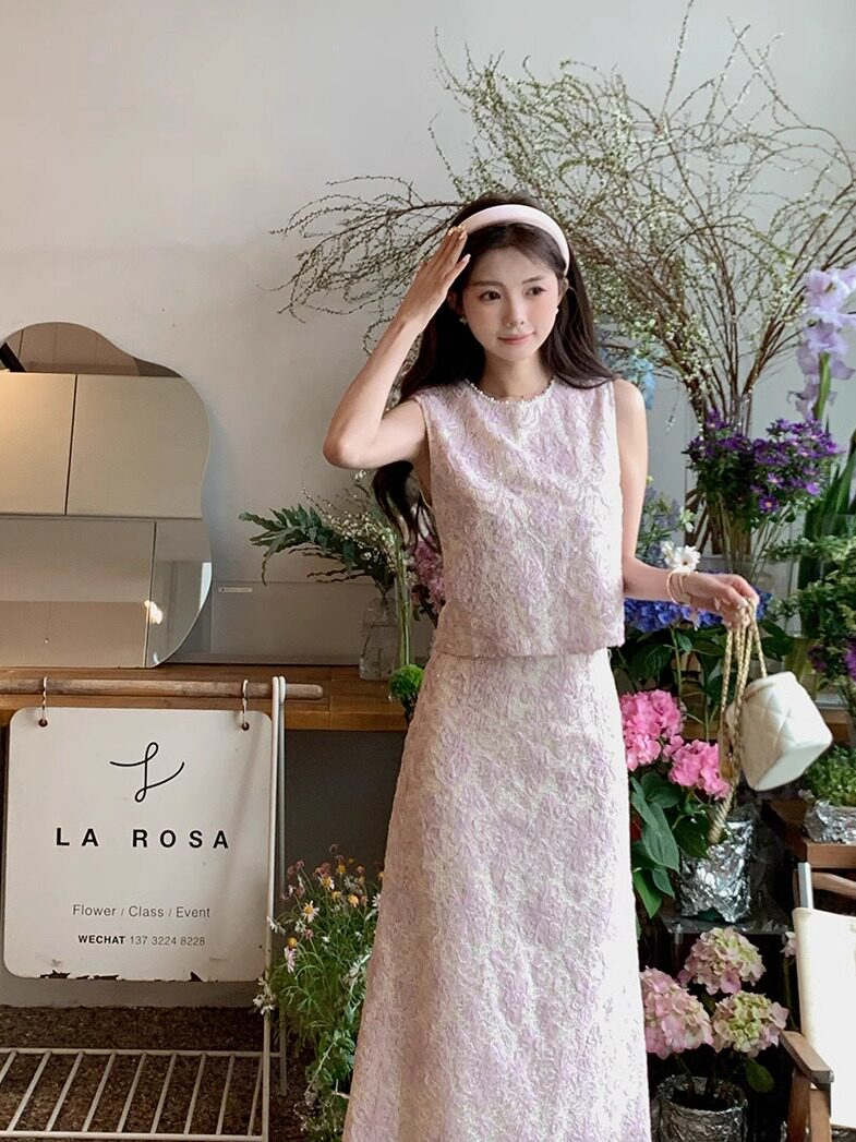 Model wearing a light pink lace dress with a matching skirt and headband