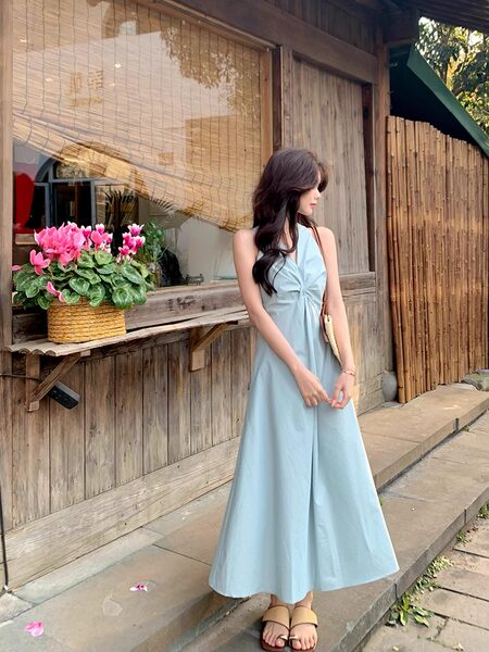 Light blue sleeveless maxi dress worn by a woman outdoors