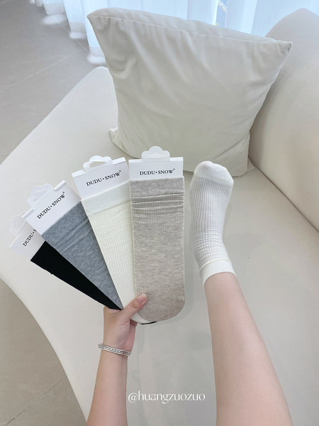 Assorted ribbed socks displayed in packaging, with one pair worn on a foot