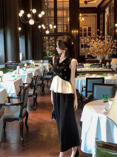 Woman wearing a black and white elegant sleeveless dress in a restaurant