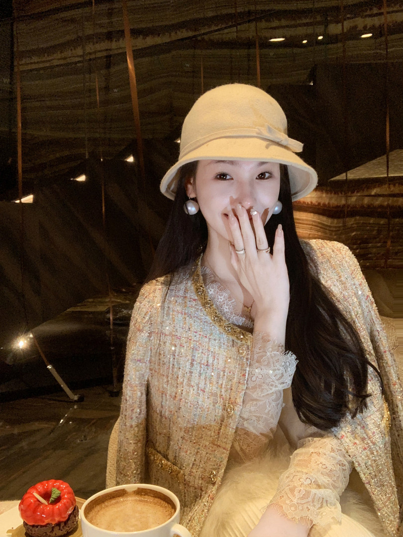 Woman wearing a beige hat and a sparkling lace-trimmed outfit