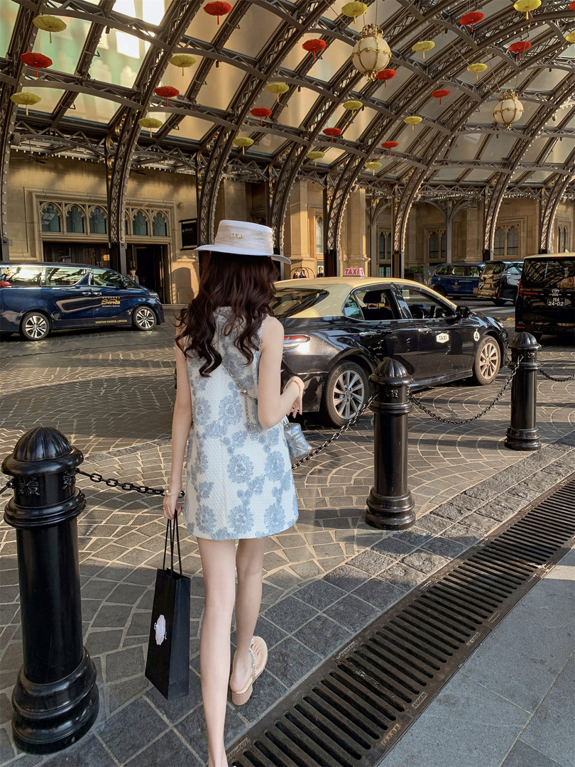 Light blue floral sleeveless mini dress worn by a model outdoors